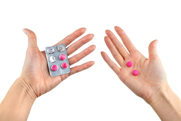 Pink pills in the hand on a white isolated background