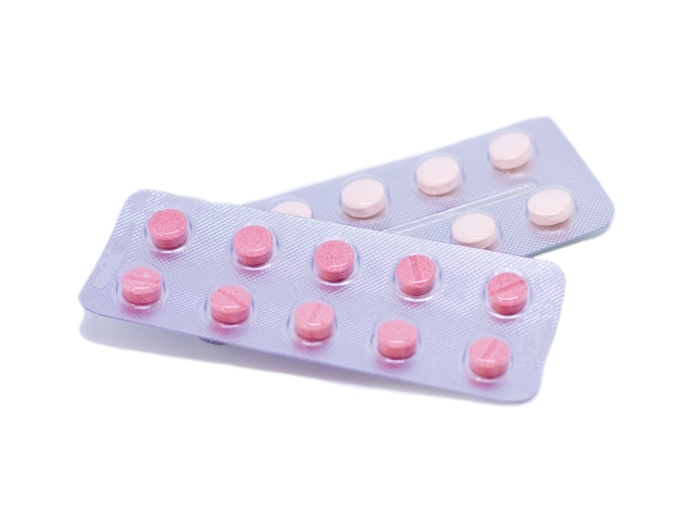 Pink pills in a package isolated on a white background