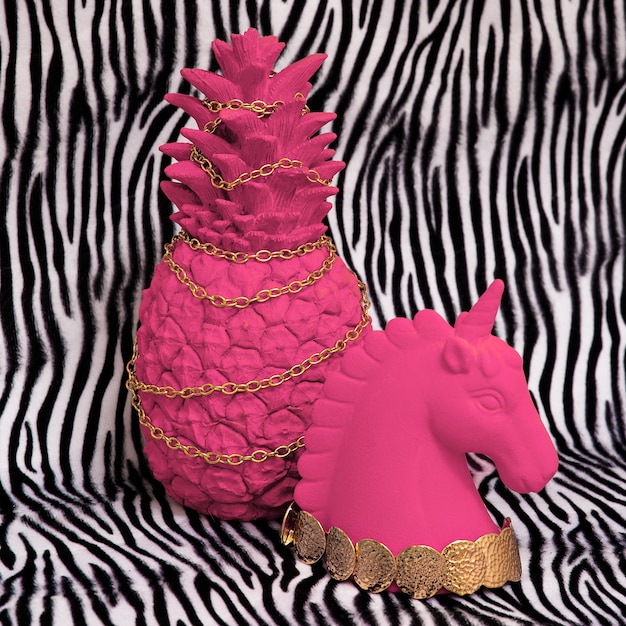 ゼブラ柄の背景にピンクのパイナップルとユニコーン。最小限のクリエイティブアート