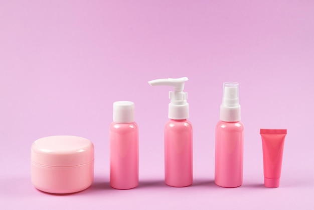 Pink plastic bottles for hygiene products cosmetics hygiene products on a pink background Copy space