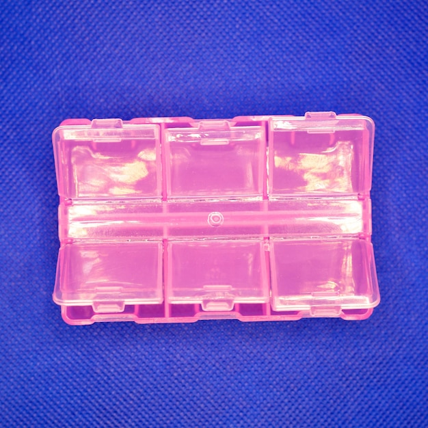 Photo pink plastic organizer with cells on a blue background