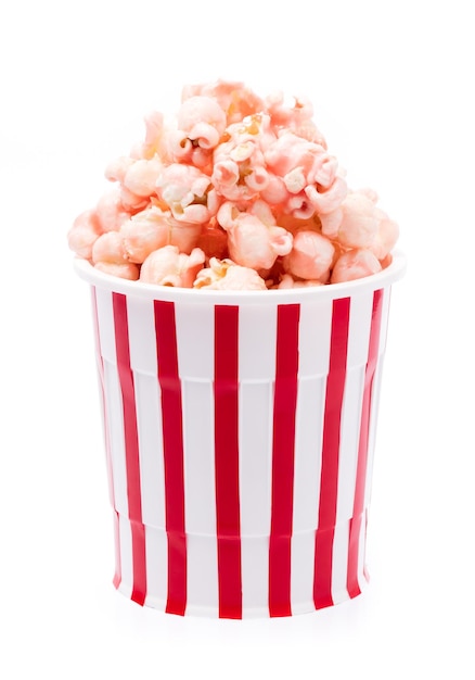 Photo pink popcorn in striped bucket isolated on white background