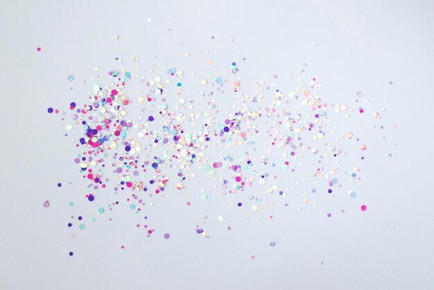 Pink purple confetti glitter glitter scattered on a white background