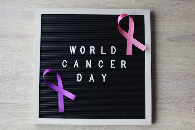 Pink and purple ribbons on letter board for world cancer day\
breast cancer alzheimers disease