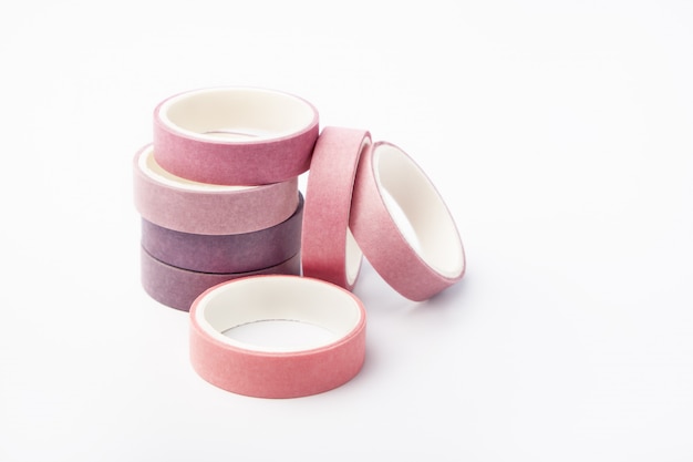 Pink and purple rolls of washi tape on a white