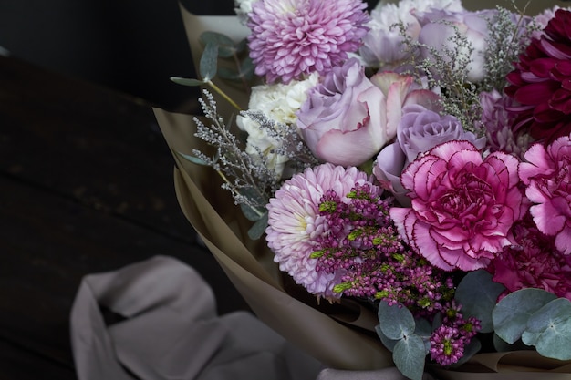 Pink and purple toned bouquet in vintage style on dark 