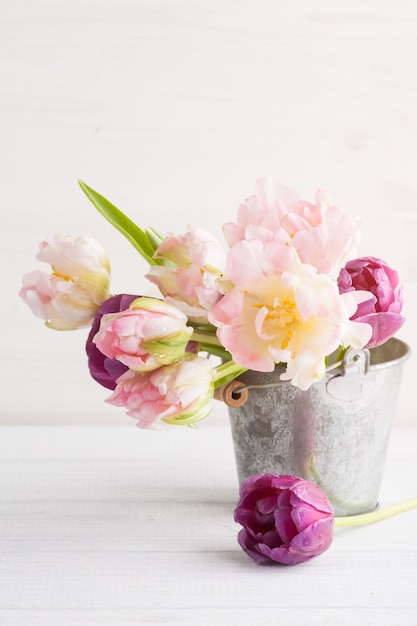 Розовые фиолетовые тюльпаны в оловянном ведре