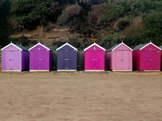 Pink and purple wooden cabins on the edge of bournemouth beach south england