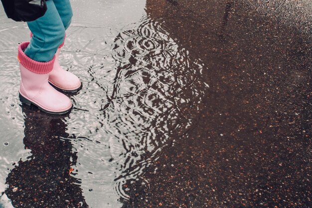 Pink rain boots and puddle