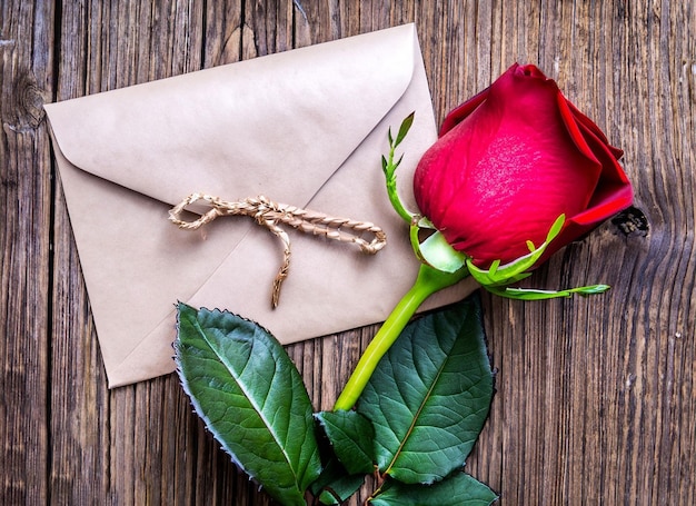 Foto fiori di ranuncolo rosa regalo o confezione regalo e biglietto vuoto con busta sul tavolo festa della mamma compleanno san valentino concetto di celebrazione della festa della donna vista dall'alto piatto