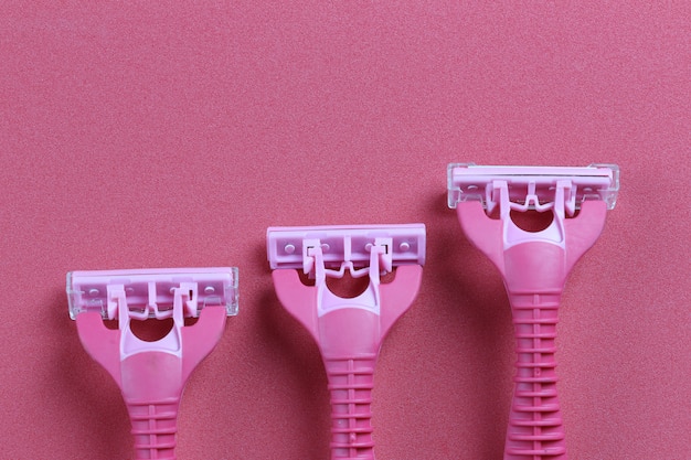 Pink razor on red art paper background.