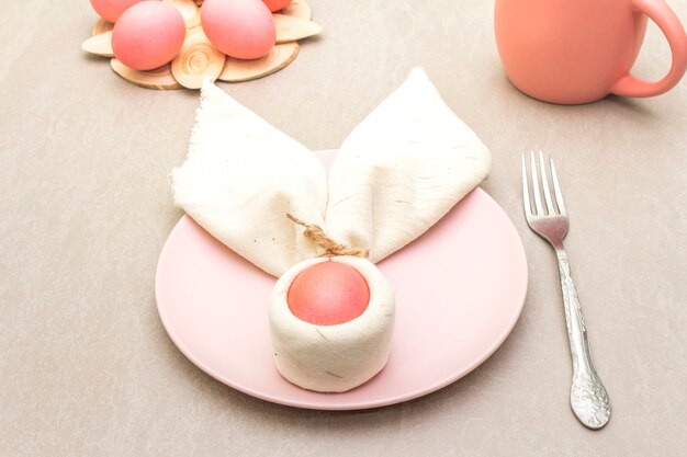 Pink and red eggs with bunny ears on a plate