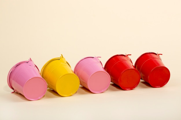 Pink, red and yellow buckets on a yellow wall