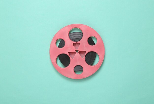 Pink retro audio reel on blue background minimalism music\
concept top view