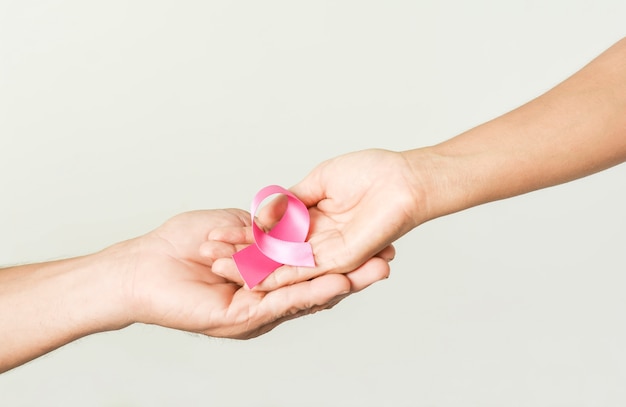 Pink ribbon bow in hand