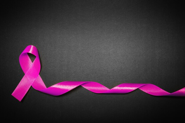 Pink ribbon for breast cancer awareness, symbolic bow color raising awareness on people living with women's breast tumor illness. bow isolated with clipping black background