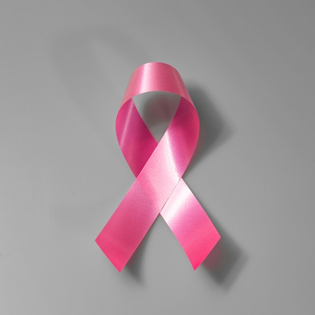 白い壁にピンクリボンの乳がん啓発。コンセプトヘルスケアと医学、癌のコンセプト