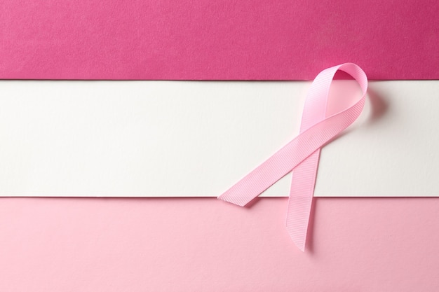 Pink ribbon on color background. Breast cancer awareness concept