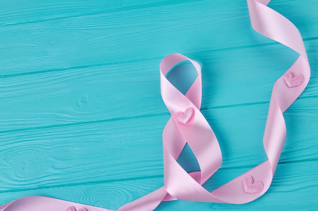 Pink ribbon tape on blue wooden desk