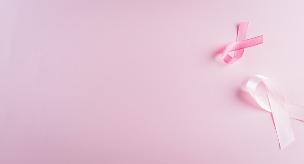 Photo pink ribbons on pastel background, symbol of women's breast cancer awareness, health care and medical concept.