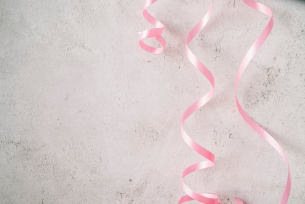 Pink ribbons on stucco background