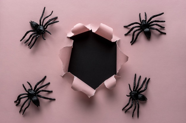 Розовая рваная бумага с фоном пауков