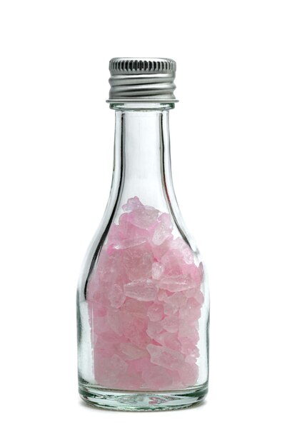 Photo pink rock sugar or crystalline sugar glass bottle isolated on white background