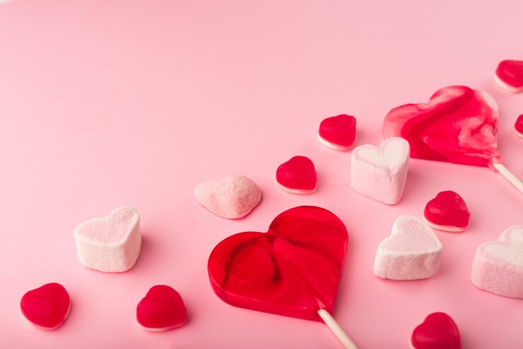 Photo ハート型の甘いお菓子とピンクのロマンチックな休日の背景。テキスト用のスペースを持つ聖バレンタインの装飾的なカード。愛のテーマ。
