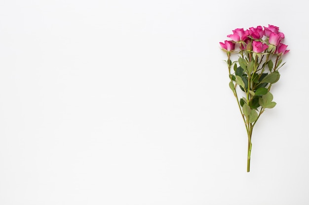 Pink rose bouquet on white wooden background. Flat lay, top view.