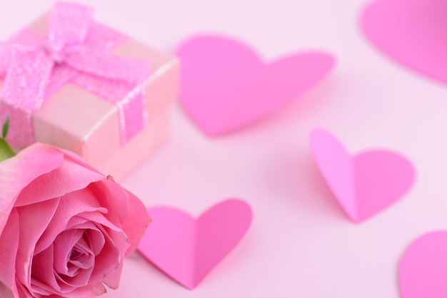 Pink rose and a gift box with hearts, valentine day background