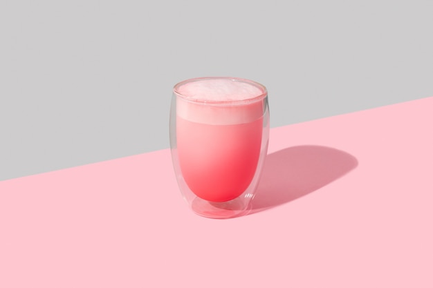 透明なガラスのピンクのバラのミルクセーキ。ミニマルなスタイルのレストラン用抹茶ラテテンプレート。
