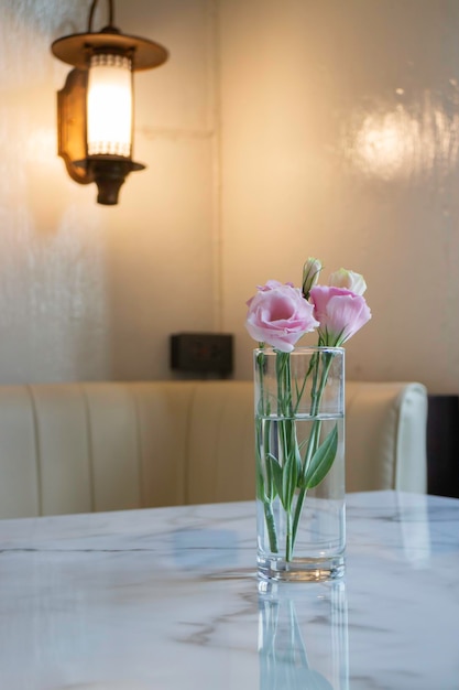 テーブルの上の花瓶にピンクのバラ
