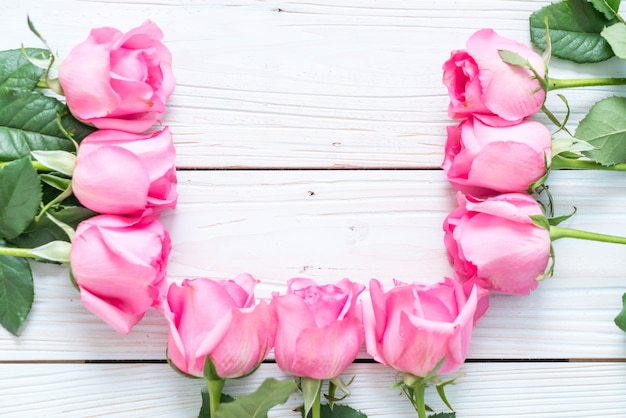 pink rose in vase on wood background