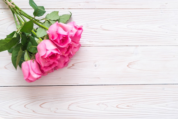 pink rose in vase on wood background