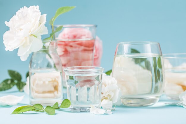 Pink roses distorted through water glasses