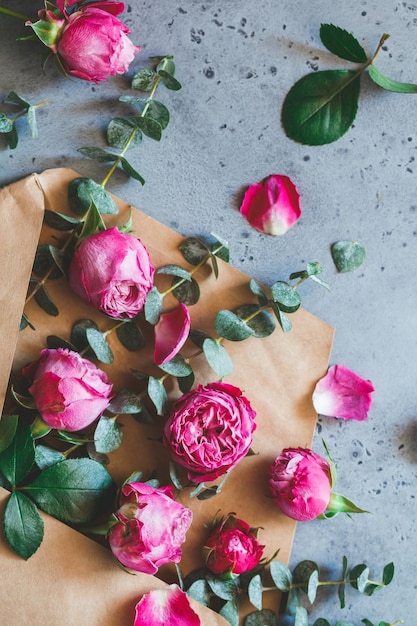 Pink roses in the envelope on a grey background The concept of greetings and celebration Soft focus