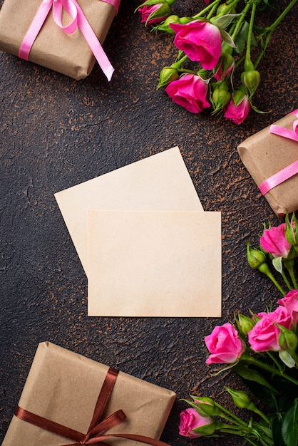 Pink roses, gift boxes and greeting card