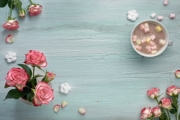 Pink roses and hot chocolate on light mint