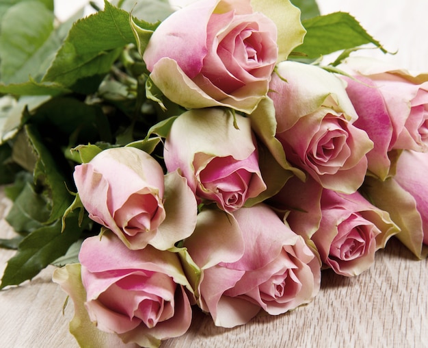 ピンクのバラは木製のテーブルで隔離
