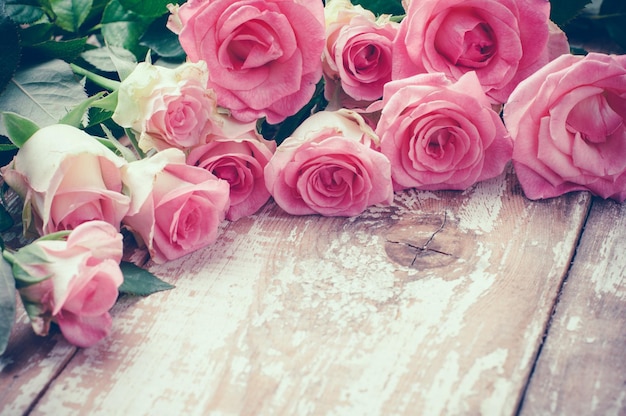 Photo pink roses on old wooden board