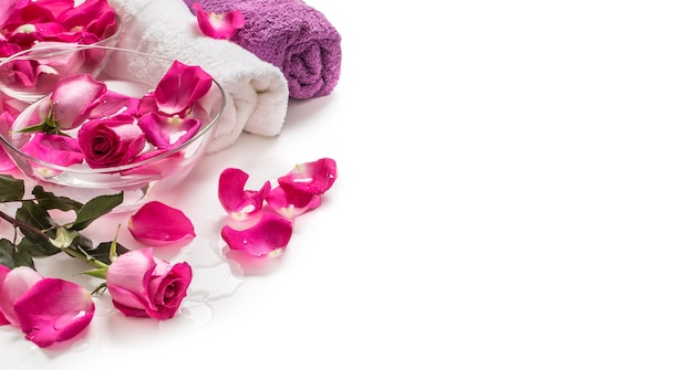 Лепестки розовых роз в шаре с полотенцами и чистой водой над белой .. концепция спа и оздоровления.