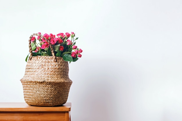 Photo pink roses in a straw basket