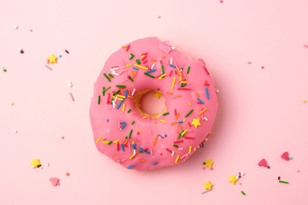 Pink round donut with colored sprinkles 