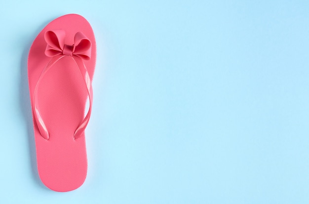 Pink rubber slippers on blue surface.