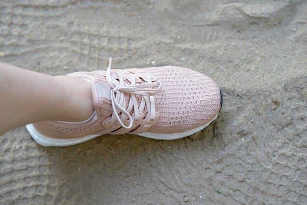 Pink runnung shoes one side stamp on sand with shoes prints