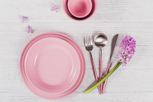 Pink rustic place setting with purple hyacinth flower and linen napkin on white wooden background