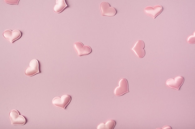 Pink satin hearts on a pink background