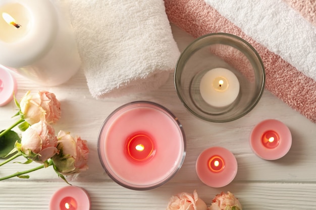 Pink scented candles on white wooden surface