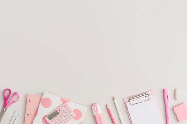 Cancelleria scolastica rosa su sfondo grigio vista dall'alto flat lay torna al concetto di scuola