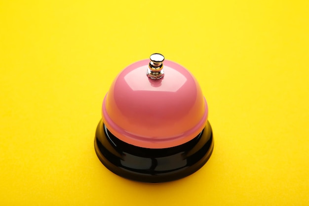 Pink service bell on a yellow background